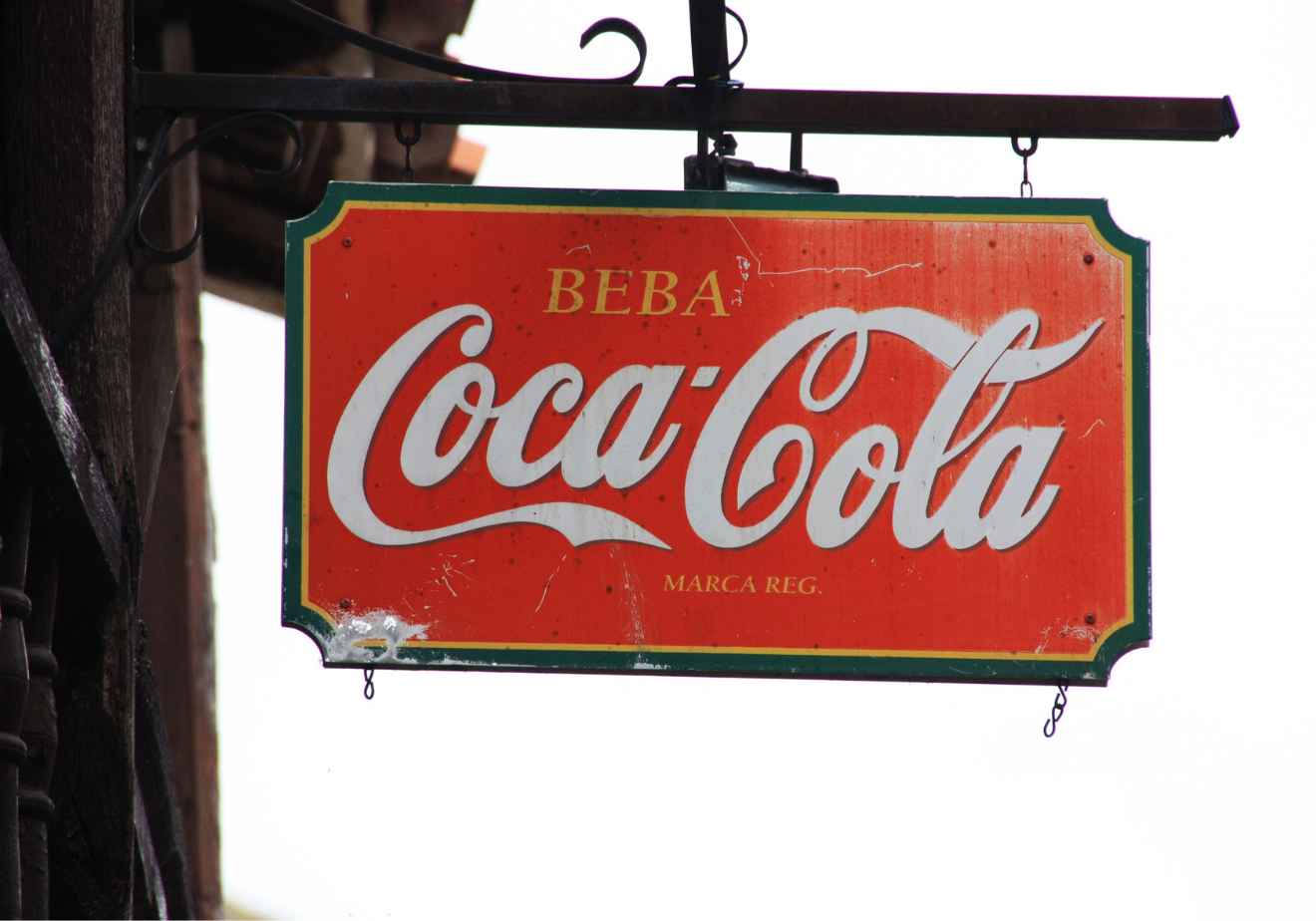 Imagen de un antigua publicidad  colgado de Coca Cola con el slogan "beba Coca Cola"