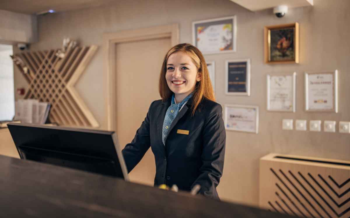 Imagen de una recepcionista usando un ejemplo de CRM en un hotel