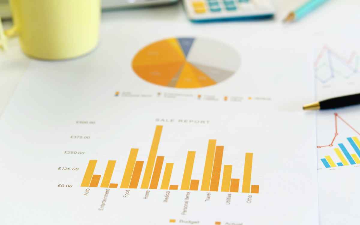 Vemos un ejemplo de reporte de ventas con representación gráfica en papel en un escritorio.
